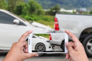 Man taking picture of truck and car crash scaled