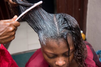 Woman having a hair relaxer applied