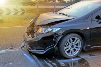 Black car with broken grille after hit and run