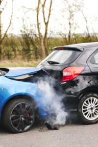 Blue car smoking after rear end crash