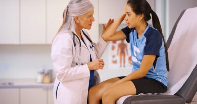 Doctor talking to patient with a concussion scaled