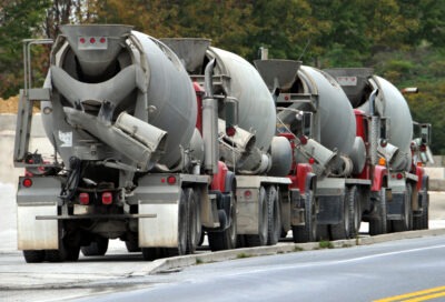 Row of several cement trucks on the side of the road scaled