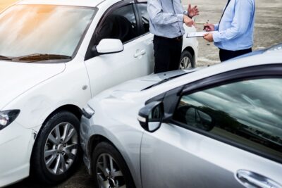 Crash victim talking to insurance agent at crash site