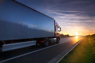 Freight truck driving at sunset