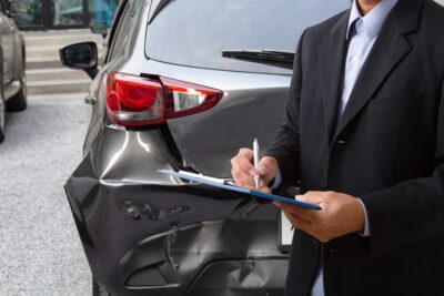 Insurance agent noting car damage