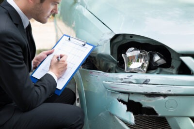 Insurance agent with clipboard at damage site scaled