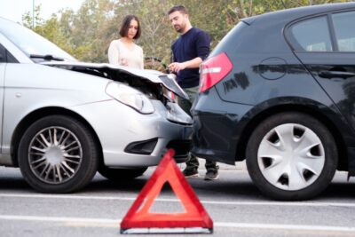 People examining damage after a car crash