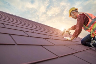 Roofer nailing down panels scaled