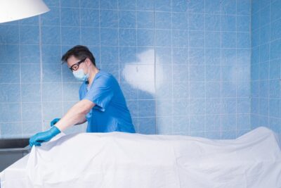 Coroner inspecting a body