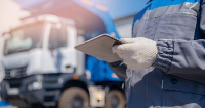 Mechanic noting truck maintenance on clipboard scaled