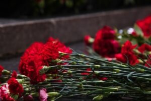 People placing roses on grave