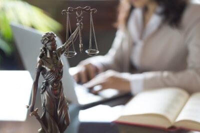 Female lawyer working next to scales of justice