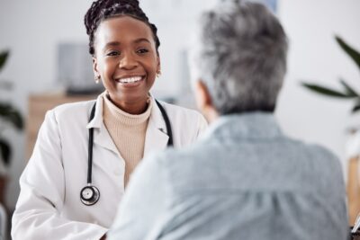 Black nurse talking to a patient