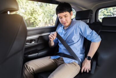 Young asian man fastening his seat belt