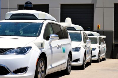 line of waymo cars at dealership