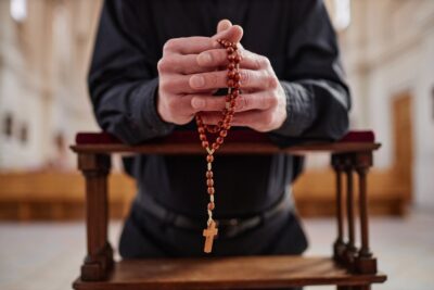 A man praying after he learned that a Georgia priest in his diocese is accused of abusing members of the congregation.