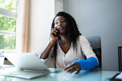 A woman who was injured while on the job talks to her lawyer on the phone and asks, “Can I get a settlement from workers’ compensation if I go back to work?”