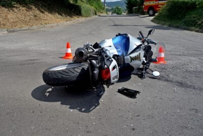 A motorcycle on its side at a crash scene. If the rider gets a motorcycle accident settlement, parts of it may be taxable in Georgia