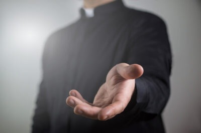 A priest holds out his hand to somebody who wonders about the long-term effects of clergy abuse.