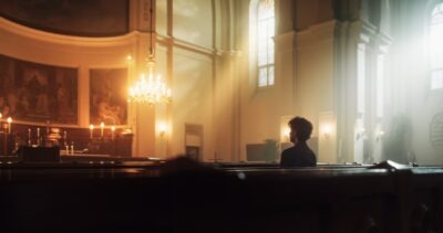 A person sits alone in a Catholic church, wondering, am I eligible to file a Catholic Church sexual abuse lawsuit?