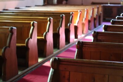 Rows of pews sit in a church. Priests go to jail for sexual abuse—but not as often as you might think. Many cases never reach a courtroom, and others are dismissed due to legal deadlines or lack of evidence.