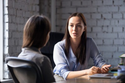 A woman talking to a lawyer about how to sue a medical provider for sexual misconduct.