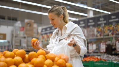 A woman looks at oranges at Walmart, moments before a slip and fall accident. She might get more than the average settlement for a slip and fall at Walmart.